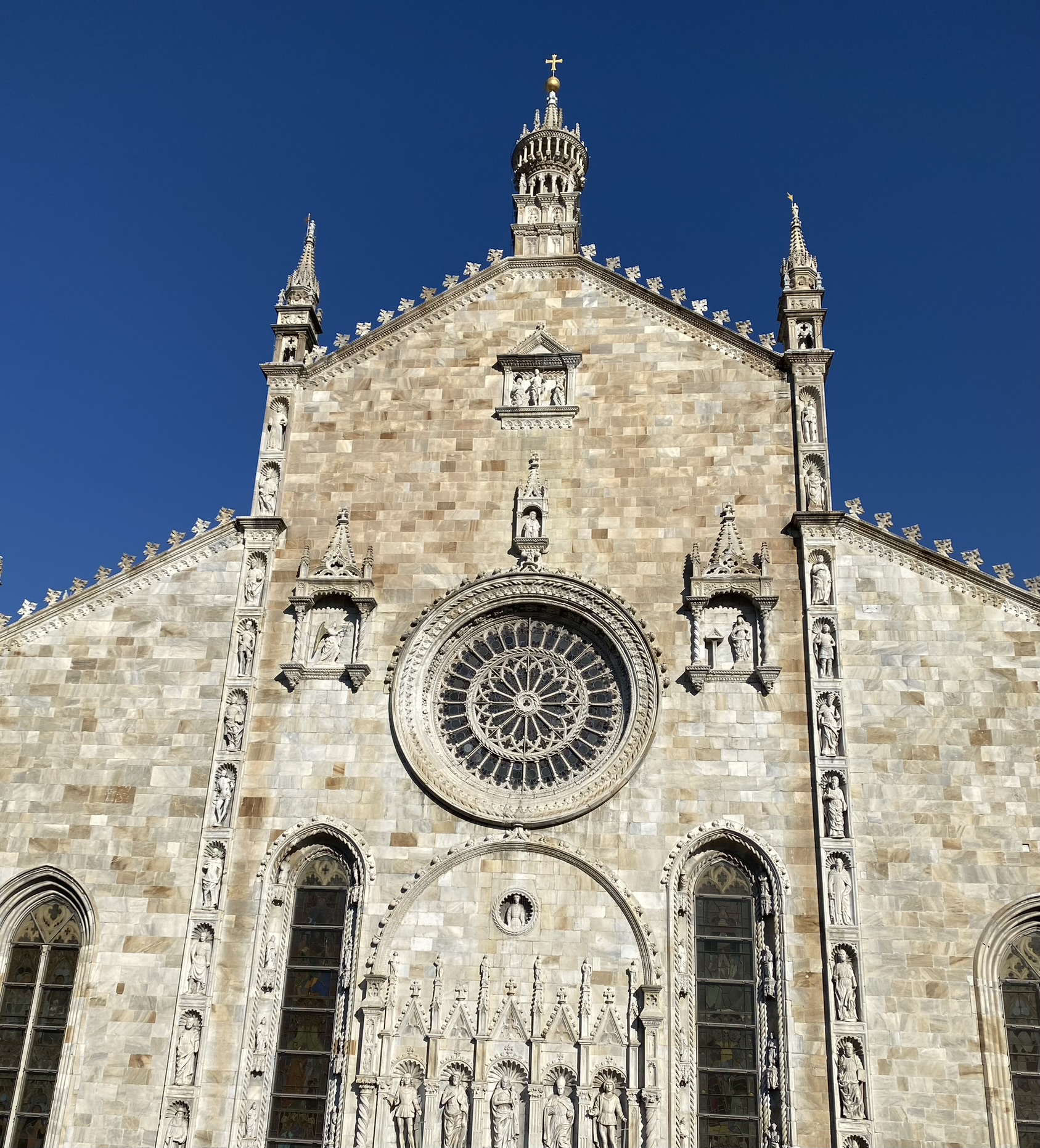Façade du Duomo de Côme sous un ciel bleu profond