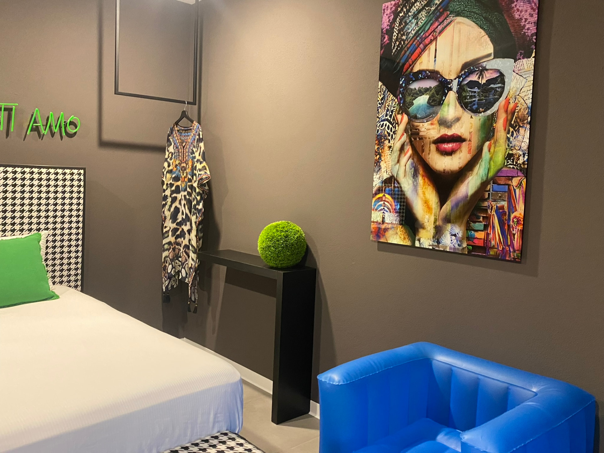 Chambre avec œuvre d'art colorée et fauteuil bleu